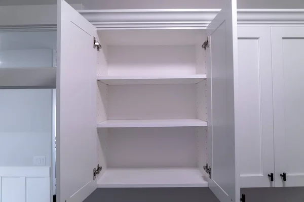 Hanging wall cabinets with open doors and shelves at a new home interior