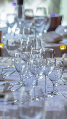 Dikey şarap kadehleri ve sofra takımı sosyal bir toplantı için bir masaya dizilmiştir.