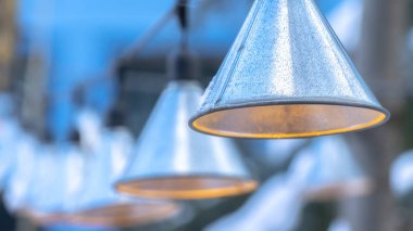 Fotoğraf Panorama çerçeve dekoratif koni şekilli lambalar kışın evin dışında siyah tellerde asılı