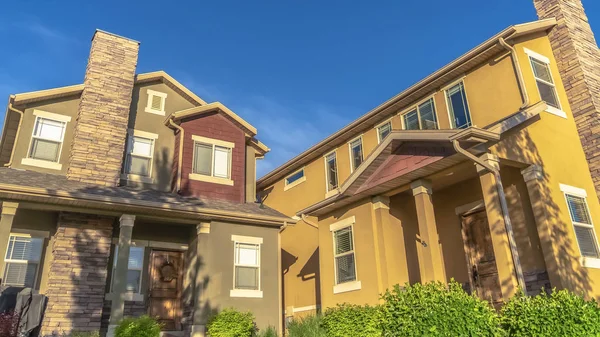 Panorama Homes with porches gable roofs and brick chimneys against vibrant blue sky — 스톡 사진