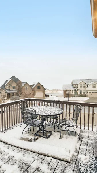 Vertical Snowy deck overlooking homes in the village blanketed with snow in winter