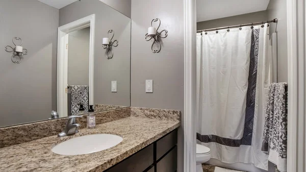 Panorama cadre Accueil salle de bain avec mur gris armoire en bois brun et comptoir en marbre — Photo