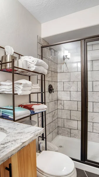 Intérieur de salle de bain verticale avec mur de tuiles noir et blanc et comptoir en marbre — Photo