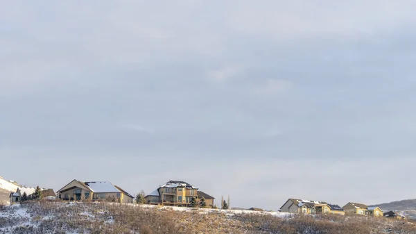 Panorama Maisons au sommet de la colline avec vue panoramique sur le terrain enneigé et la beauté naturelle — Photo