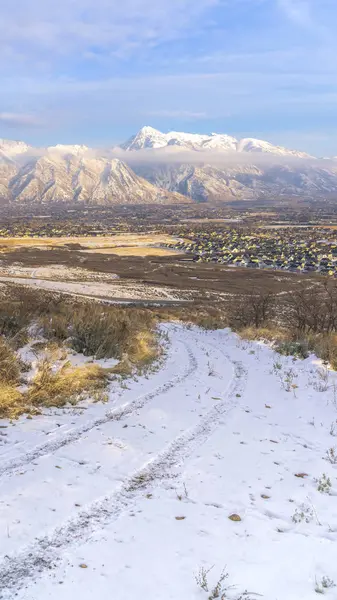 Marco vertical Camino de tierra en terreno montañoso con residencias y vista al monte Timpanogos en invierno —  Fotos de Stock