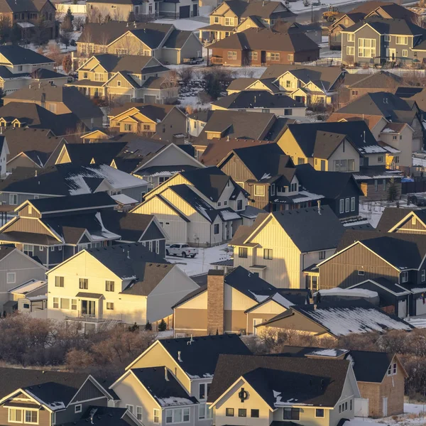 Foto quadratische Häuser mit schneebedeckten Dächern und verschneiten Höfen, die im Winter vom Sonnenlicht beleuchtet werden — Stockfoto