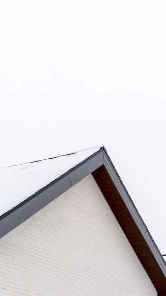 Foto Vertical Home exterior con vista de cerca del techo a dos aguas cubierto con hoja de nieve — Foto de Stock