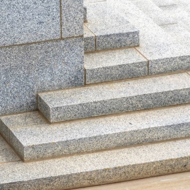 Güneşli bir günde bir binanın köşesine çıkan kare merdiven.