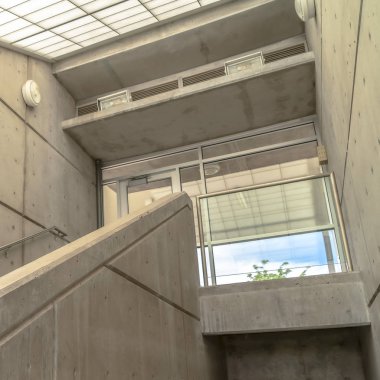 Kare çerçeve binası, eğimli cam çatılı merdiven, cam balkon kapısına çıkıyor.