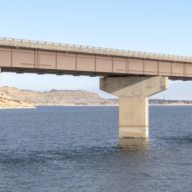 Stringer Meydanı köprüsü, göl arazisi ve bulutlu gökyüzü gibi görünen katmanlarla desteklenmektedir.