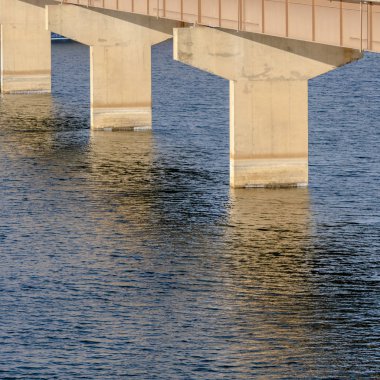 Stringer köprüsü karlı arazi ve bulutlu gökyüzü manzaralı sakin göl üzerinde yayılıyor