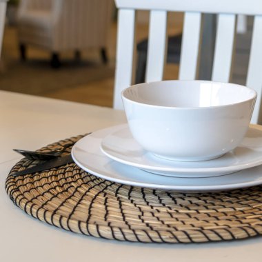 Kare fotoğraf masası, kase tabakları, kap kaplar, minder ve ahşap sandalye.