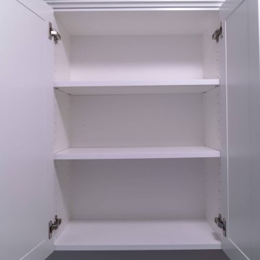 Kare çerçeve, yeni bir evin içinde açık kapı ve rafları olan duvar dolapları asılı.