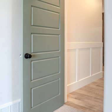 Fotoğraf Meydanı çerçeveli ev içi, gri kapının üzerinde siyah kapı kolu olan transom pencereli.