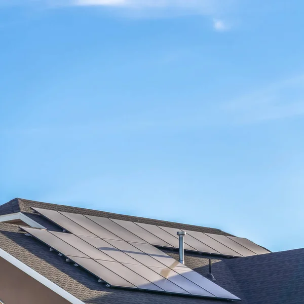 Güneş panelleri ve mavi gökyüzü arka planında havalandırma delikleriyle evin kare gri çatısı — Stok fotoğraf