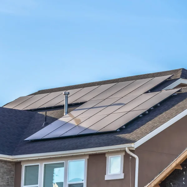 Quadrado quadro telhado cinza de casa com painéis solares e aberturas de tubulação contra fundo céu azul — Fotografia de Stock
