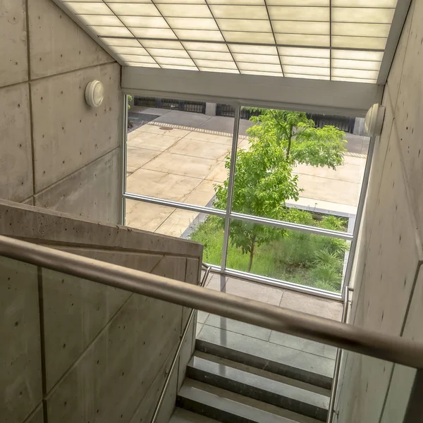 Vôo quadrado de escadas de um edifício com corrimãos de metal e telhado de vidro inclinado — Fotografia de Stock