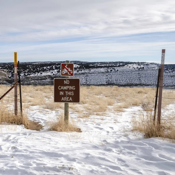 Señales de advertencia cuadradas y cerca de alambre en una colina cubierta de nieve blanca en invierno — Foto de Stock