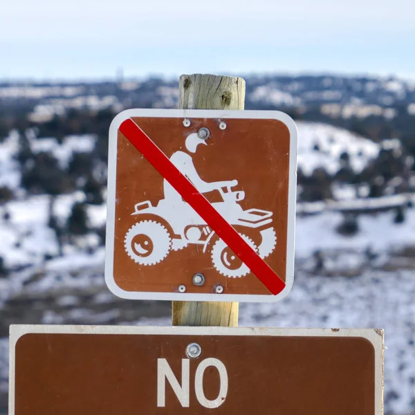 Square No Camping In This Area sign against a grassy landscape blanketed with snow — 스톡 사진