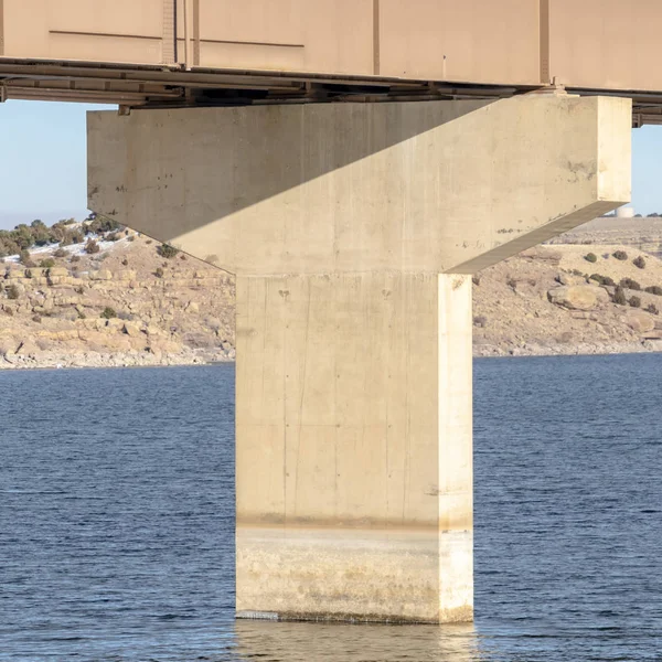 Puente cuadrado y cimentación del muelle sobre el agua azul del lago contra la montaña y el cielo azul —  Fotos de Stock