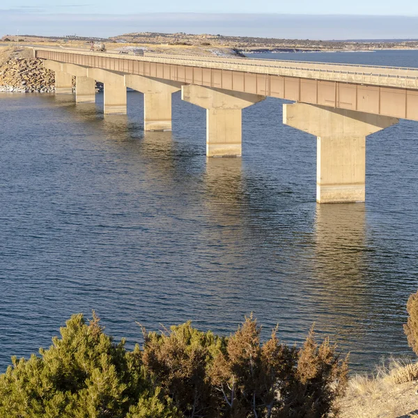 Cadre carré Lac bleu avec pont reliant de vastes terrains recouverts de neige en hiver — Photo