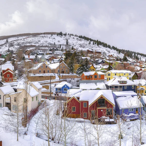 Cuadrados Casas coloridas y colinas pintorescas cubiertas de nieve blanca durante la temporada de invierno — Foto de Stock