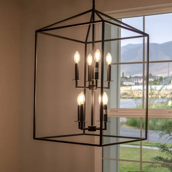 Quadratischer Rahmen hängender geometrischer Kerzenhalter gegen Fenster im Inneren des Wohnzimmers — Stockfoto