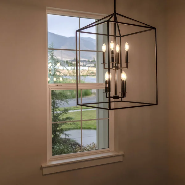 Quadratischer Rahmen hängender geometrischer Kerzenhalter gegen Fenster im Inneren des Wohnzimmers — Stockfoto