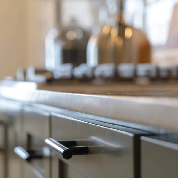 Armário de madeira quadrado com alças pretas e gavetas dentro da cozinha de casa — Fotografia de Stock