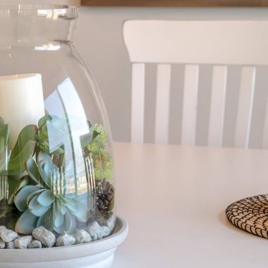 Kare çerçeve dekoratif cam kavanoz ile ev yemek masasında bitkiler ve mum