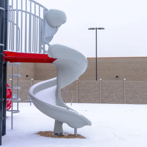 Photo Square Playground slides on park ground blanketed with fresh snow in winter