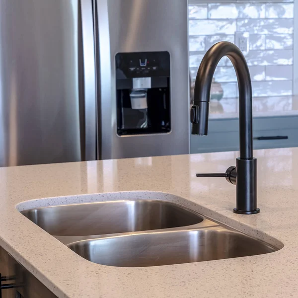 Foto quadratischer Rahmen schwarzer Wasserhahn und doppelte Schale unter der Spüle auf der Kücheninsel des Hauses — Stockfoto