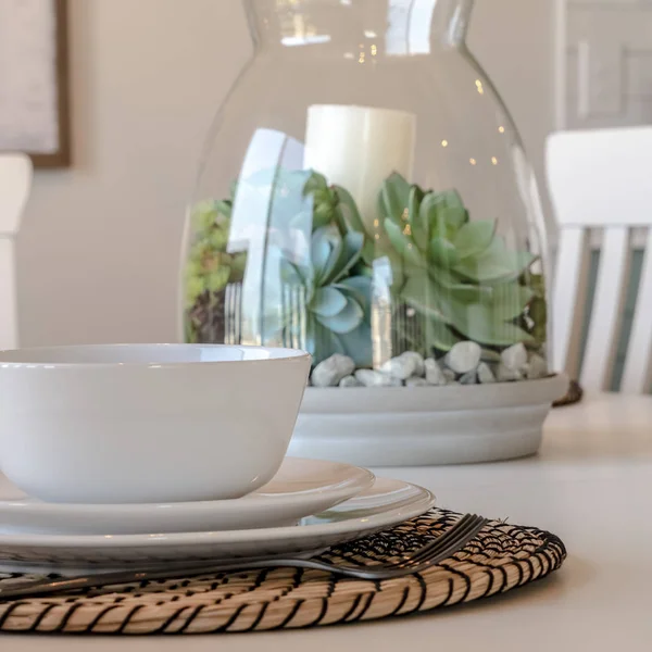 Čtvercový rám Jídelní stolní nádobí a kulaté prostírání proti svíčce a rostlinnému středu — Stock fotografie