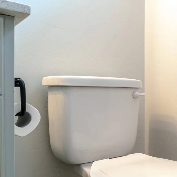 Square frame Toilet beside a trash can and bathroom cabinet with tissue roll holder — 스톡 사진