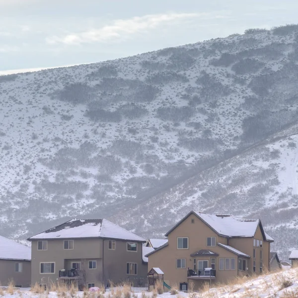 Photo Square Maisons enneigées au sommet d'une colline avec vue panoramique sur le paysage enneigé en hiver — Photo