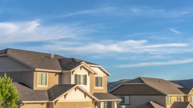 Panorama frame Vibrant blue sky with clouds over houses and hill viewed on a sunny day