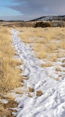 Karla kaplı dikey yürüyüş yolları kışın manzaralı tepeler ve gölle kaplı.