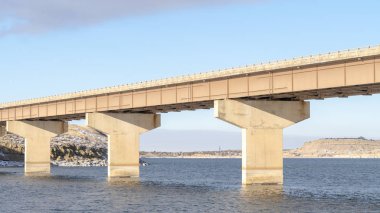 Panorama Stringer köprüsü mavi bir gölün üzerinden geçiyor ve karlı kayalık arazileri birbirine bağlıyor