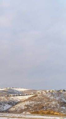 Dikey çerçeve. Güzel doğal manzara. Karla kaplı tepelerin üzerine yuva yapmış evler.