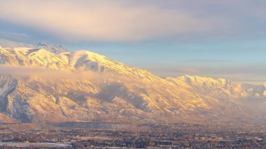 Fotoğraf: Panorama Karlı Timpanogos Dağı gün batımında altın güneş ışığıyla aydınlatılır.