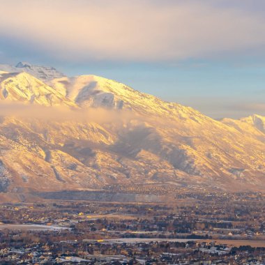 Kare çerçeve Karlı Timpanogos Dağı gün batımında altın güneş ışığıyla aydınlatılıyor