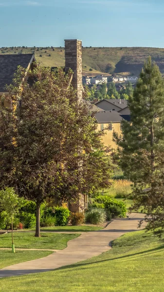 Paesaggio residenziale verticale con sentieri e prato erboso di fronte a case di charme — Foto Stock