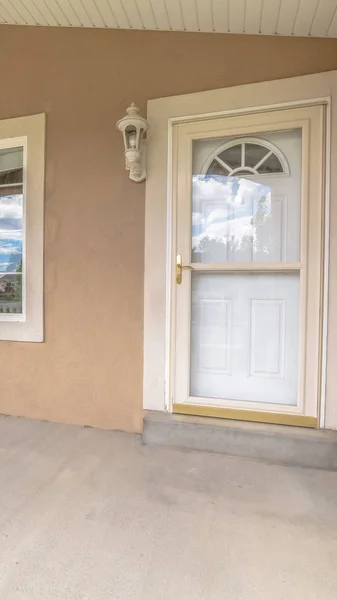 Vertical frame Front porch white front door with glass panes and windows at the home entrance