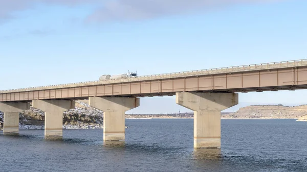 Panorama Stringer Brücke wird von Widerlagern gestützt, die das Seeland und den wolkenverhangenen Himmel überspannen — Stockfoto