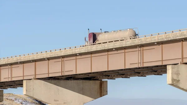 Φορτηγό Πανόραμα με μεγάλο δοχείο δεξαμενών που ταξιδεύουν σε μια γέφυρα πάνω από τη λίμνη σε μια ηλιόλουστη μέρα — Φωτογραφία Αρχείου