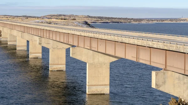 Panorama Beam bridge with deck supported by abutments or piers spanning over blue lake