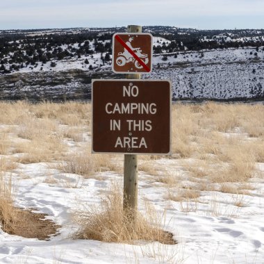 Kare çerçeve uyarı işaretleri ve beyaz karla kaplı bir tepenin tel örgüsü