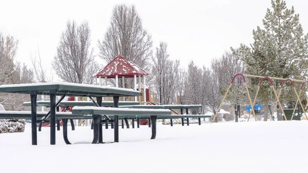 Photo Panorama Gruba warstwa białego śniegu pokrywająca park placem zabaw i terenem piknikowym — Zdjęcie stockowe