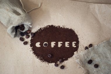 Kağıt üzerinde tuval çanta ve zemin kahve kahve çekirdekleri.