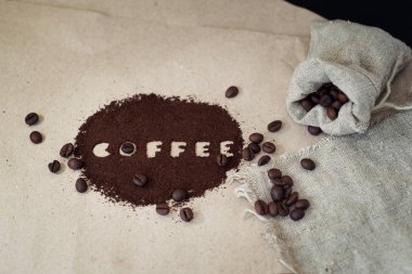 Kağıt üzerinde tuval çanta ve zemin kahve kahve çekirdekleri.